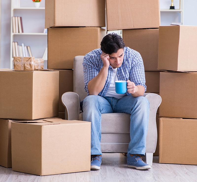  young man moving in to new apartment with boxes