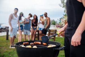 graphicstock closeup of young man standing and cooking sauseges on barbeque party BOe2 SBI 302739650