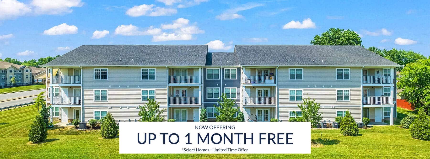 A three-story apartment building with balconies is shown on a sunny day, with a sign offering up to one month free rent for select homes at Clearwater Heights as a limited time offer.